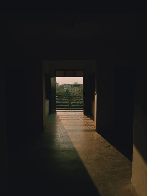 Free A quiet corridor with open doors leading to sunlight, capturing shadows in Dhaka. Stock Photo