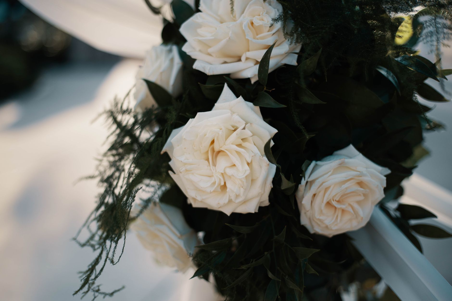 Captivating white rose bouquet with lush greenery, perfect for weddings and special occasions.