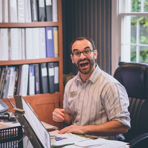 Free Man Laughing While Sitting on Office Chair Stock Photo