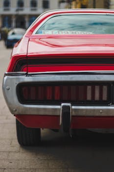 Close-up of a vintage red Dodge Charger parked outdoors.