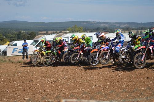 Free Riders in colorful gear race through a dirt track, showcasing speed and skill in an off-road competition. Stock Photo