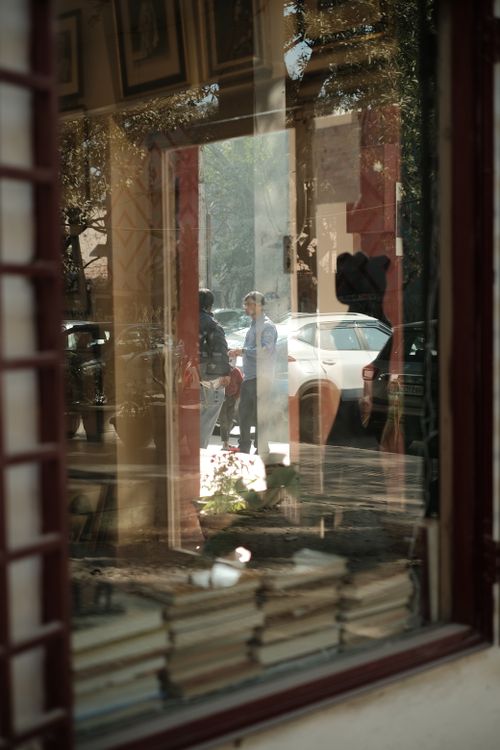 Free Intriguing reflection of city life and books through a window pane. Stock Photo