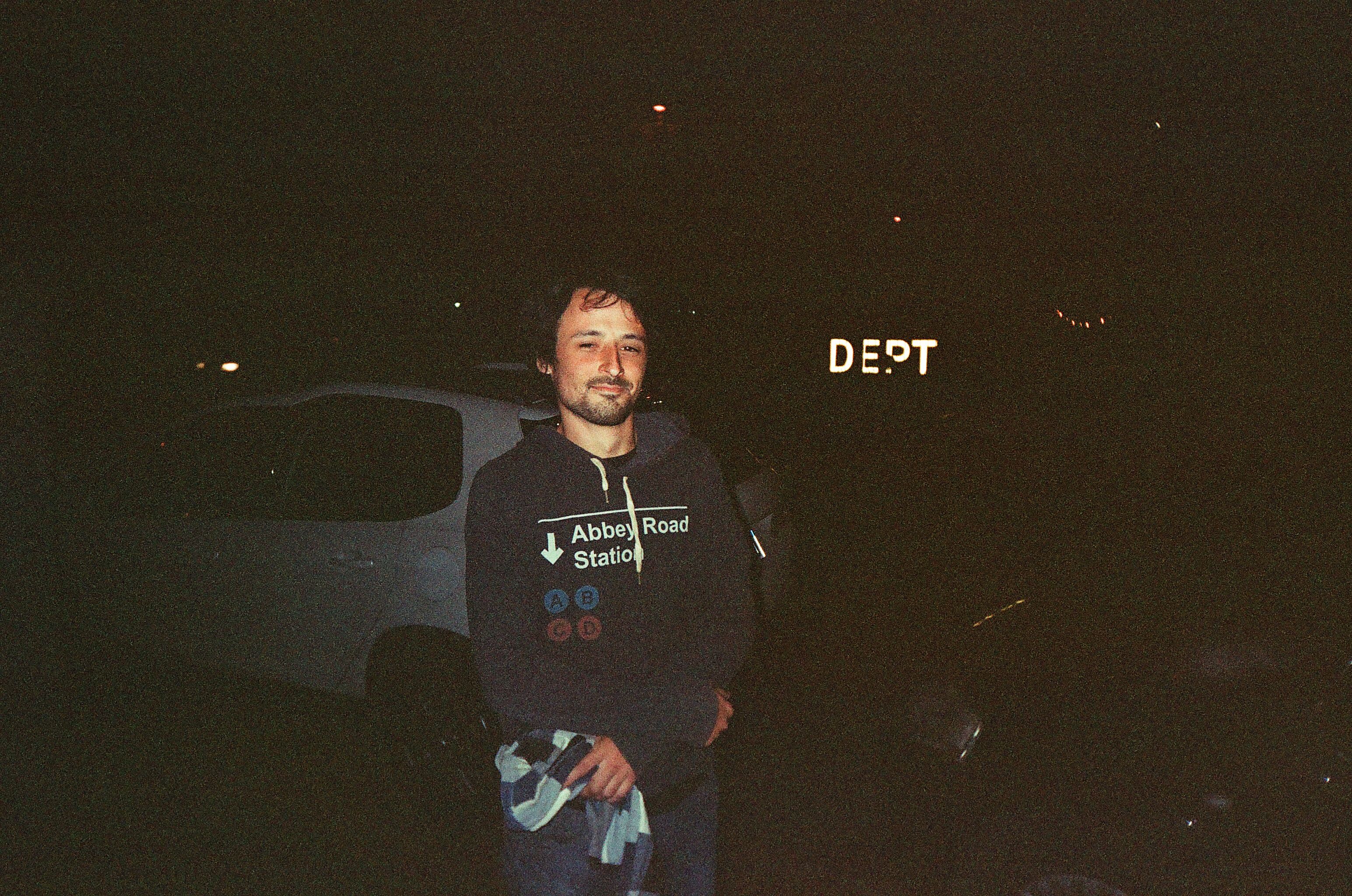 A man in a black hoodie stands outside at night in Mar del Plata, Argentina.