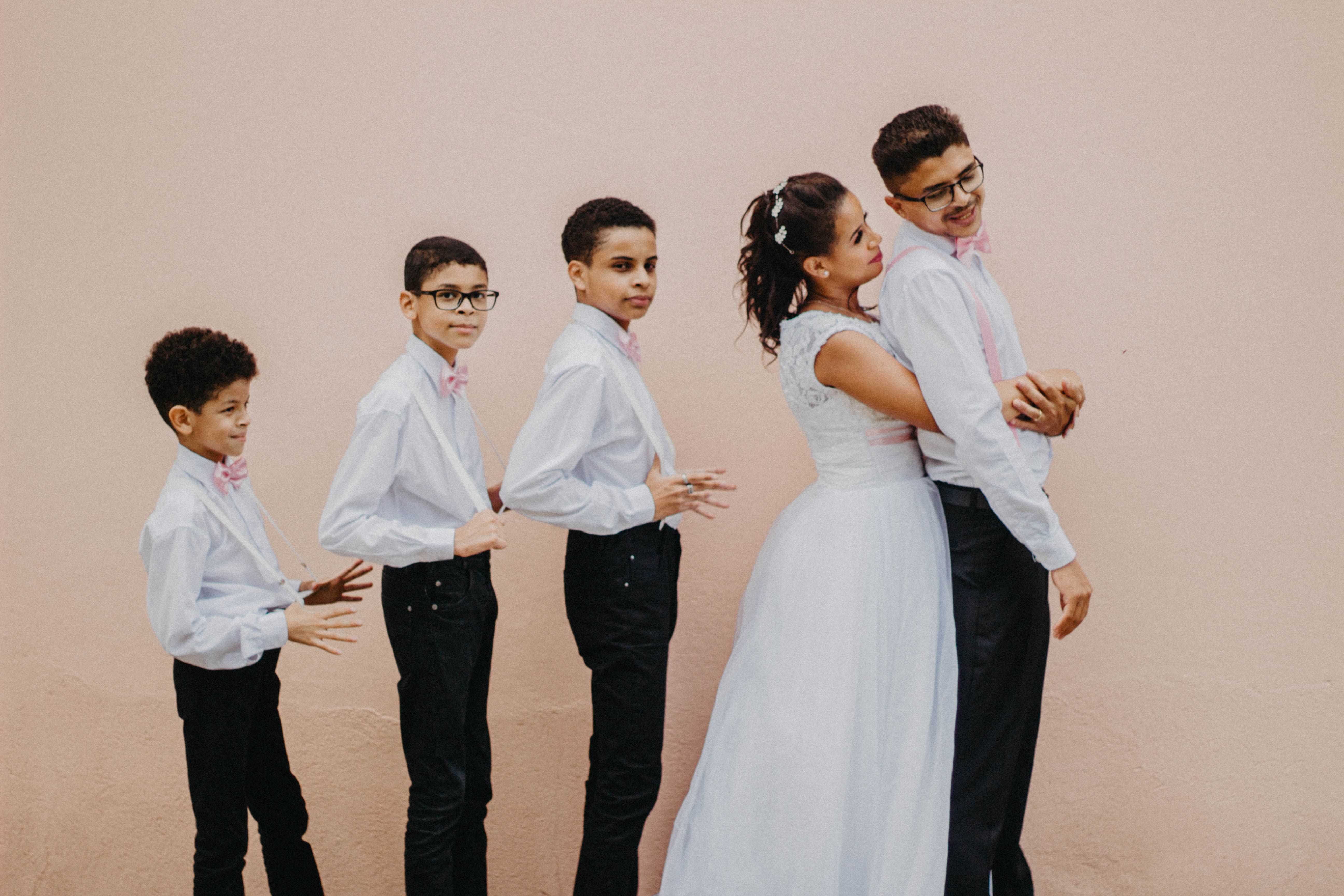 Joyful family portrait with siblings lining up at a wedding celebration.