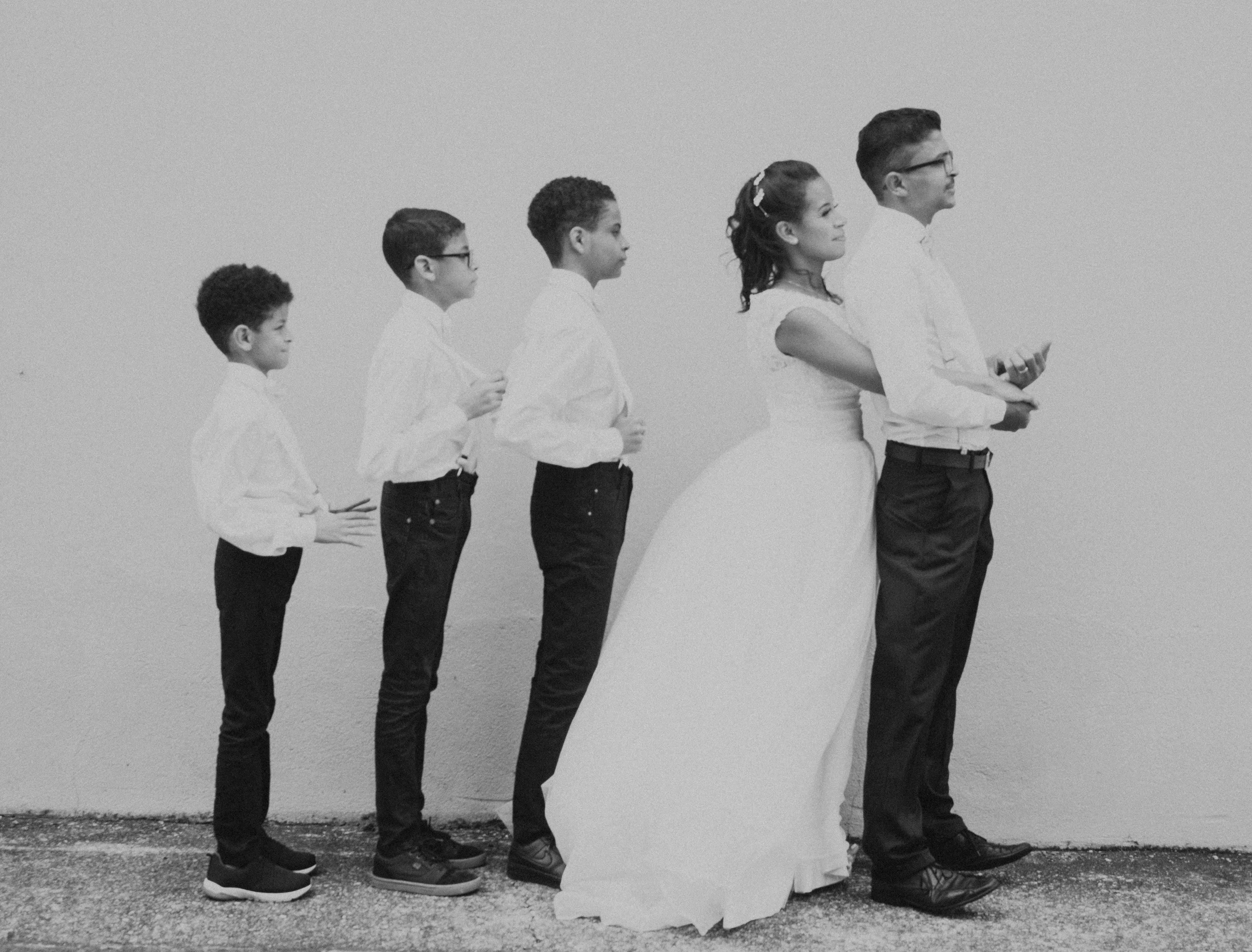 Artistic black and white family portrait with children and a bride and groom.