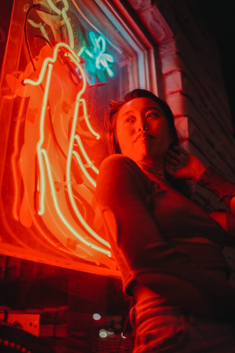 Woman Standing Next To Neon Light