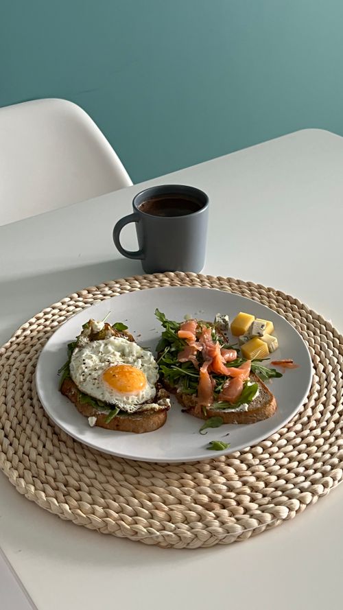 Free A hearty breakfast of egg and salmon toasts paired with a mug of coffee. Stock Photo