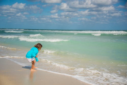 Child on Sand Seashore near Water