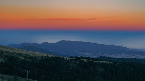 Free A stunning aerial view of sunset over rolling hills, capturing nature's vibrant and serene beauty. Stock Photo