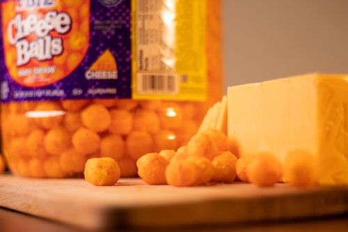 Free Cheese Balls on a wood cutting board with cheese Stock Photo