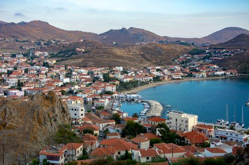 Free Aerial view of a picturesque Mediterranean bay town with red-roofed houses and a marina. Stock Photo