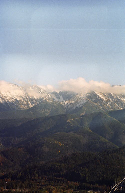 Green Mountains with Snowcapped Peaks Hidden in the Clouds