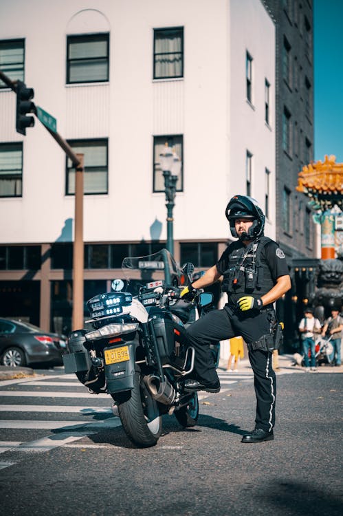 Free Policeman in a Uniform Standing by His Motorcycle  Stock Photo