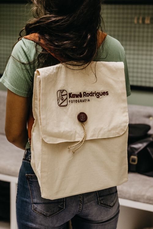 Free Back view of a woman with a stylish canvas backpack indoors. Fashionable and trendy look. Stock Photo