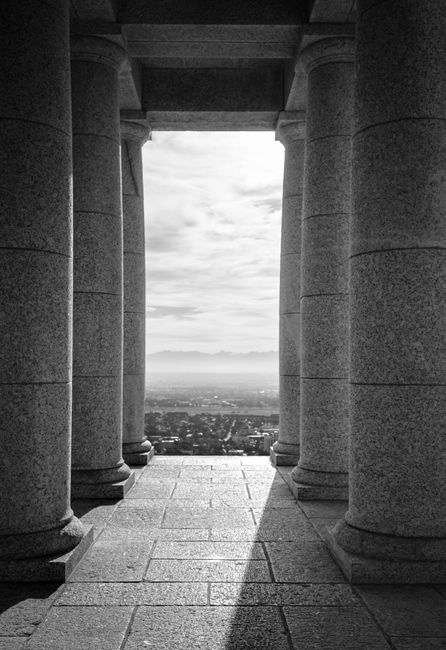 Classic black and white view through columns overlooking a cityscape.