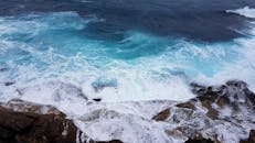 从高角度动态拍摄海浪撞击岩石海岸，捕捉自然美景