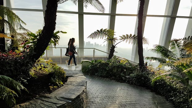 一个女人走过伦敦的空中花园，四周环绕着郁郁葱葱的绿植