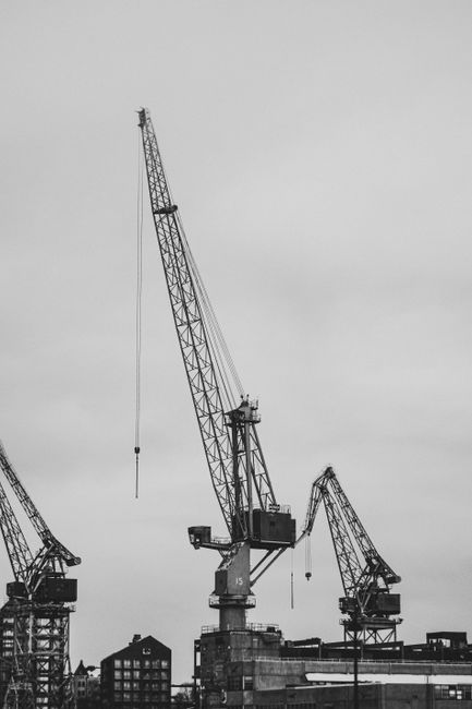 Monochrome photograph of a crane at an industrial dockyard, highlighting machinery.