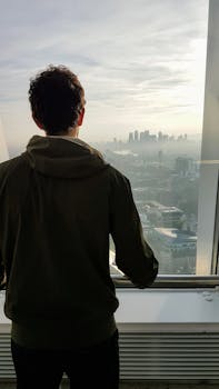 一名男子从伦敦的摩天大楼上凝视着城市天际线的景色