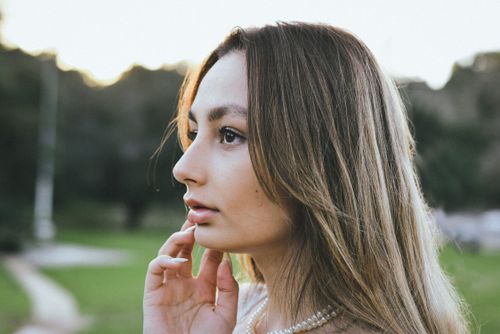Free A young woman with long hair in a serene outdoor setting, showcasing natural beauty. Stock Photo