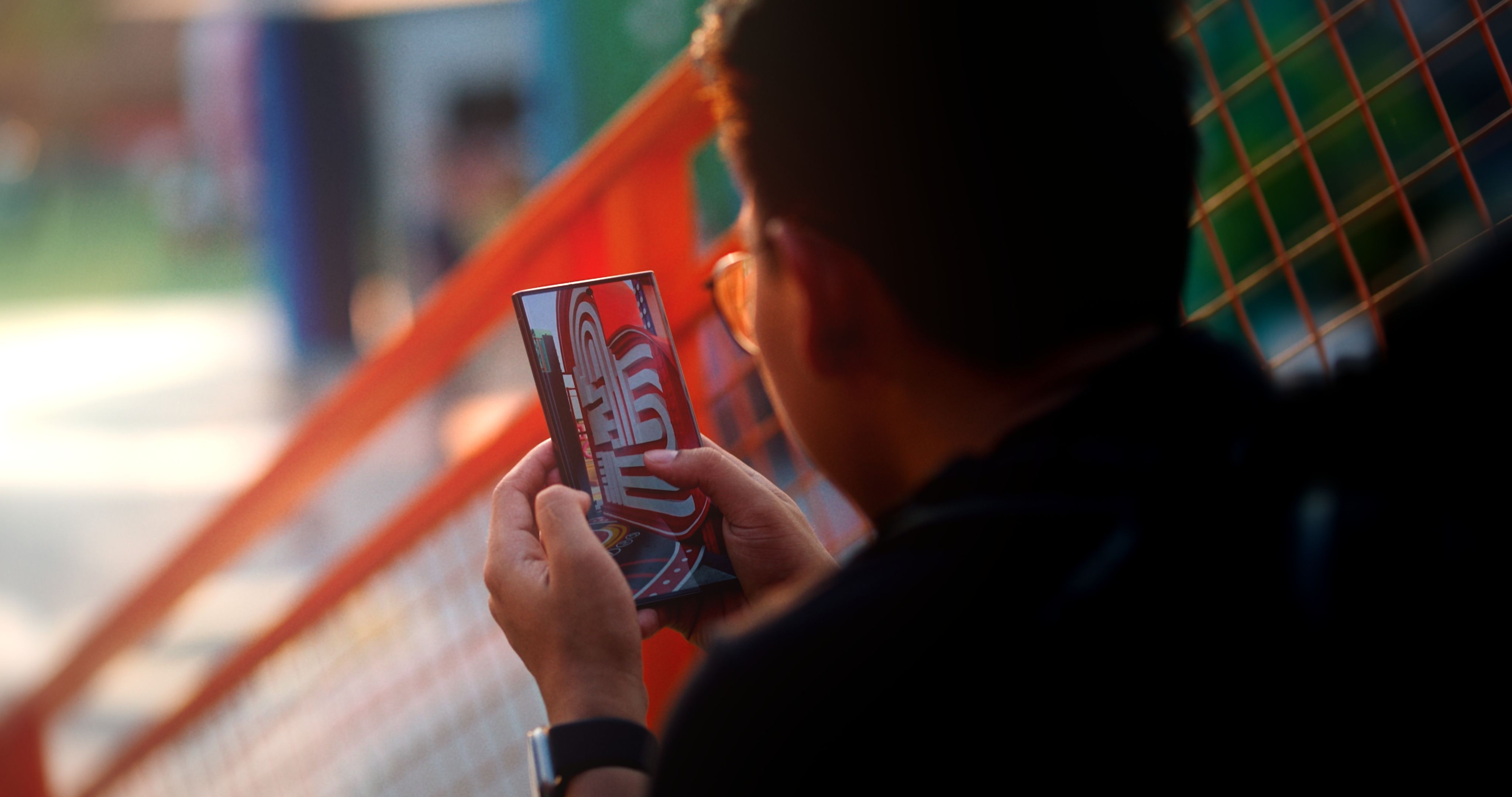 A man sitting on colorful urban steps using a smartphone.