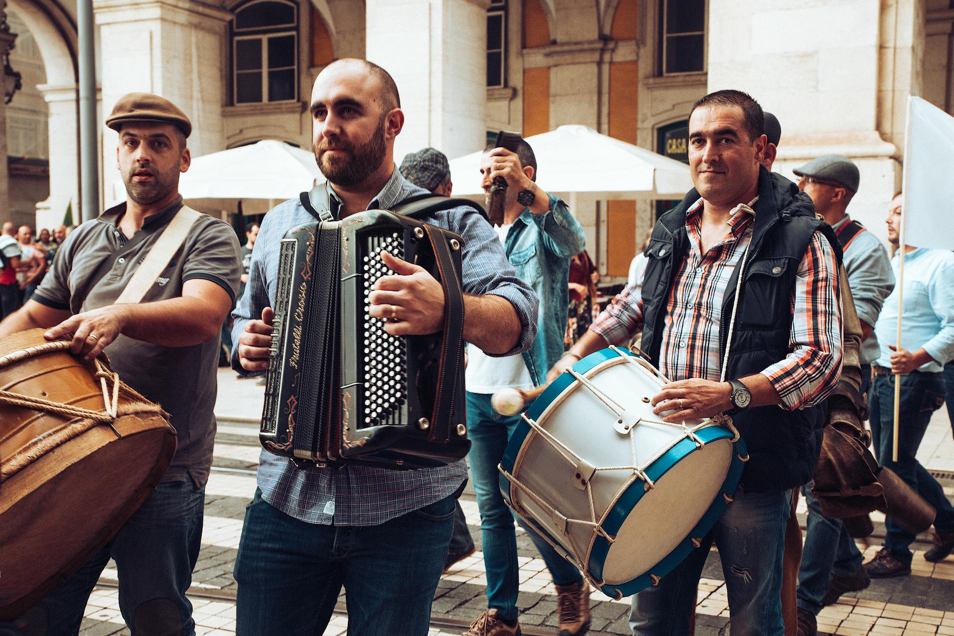 A vibrant street band playing in Lisbon, featuring drums and accordion with an engaged crowd.