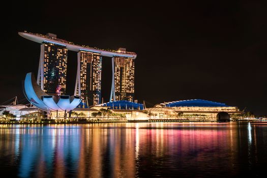 Illuminated Marina Bay Sands and ArtScience Museum reflecting on Marina Bay at night, Singapore.