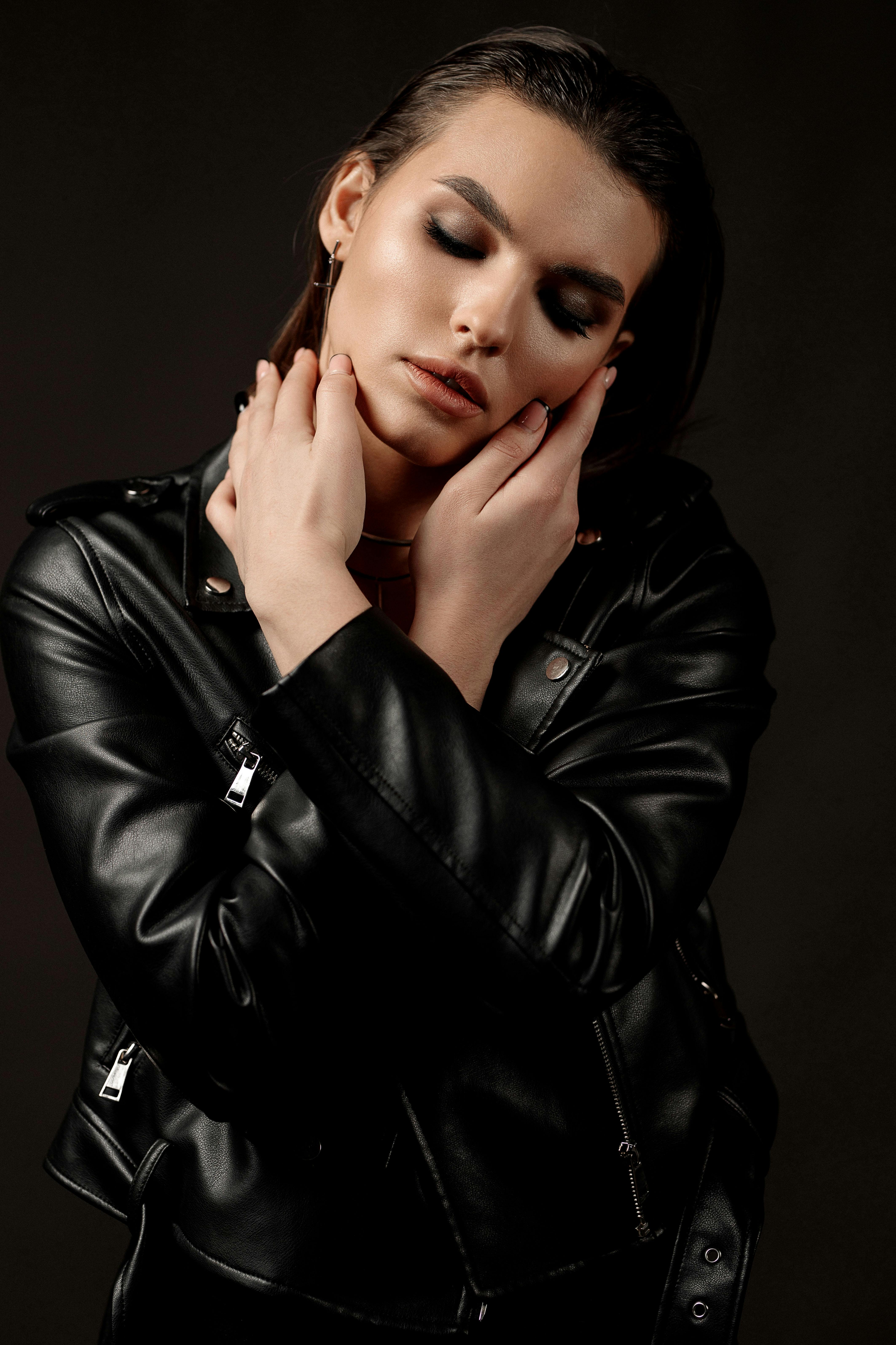 A Woman Wearing a Leather Jacket while Eyes Closed Free Stock Photo