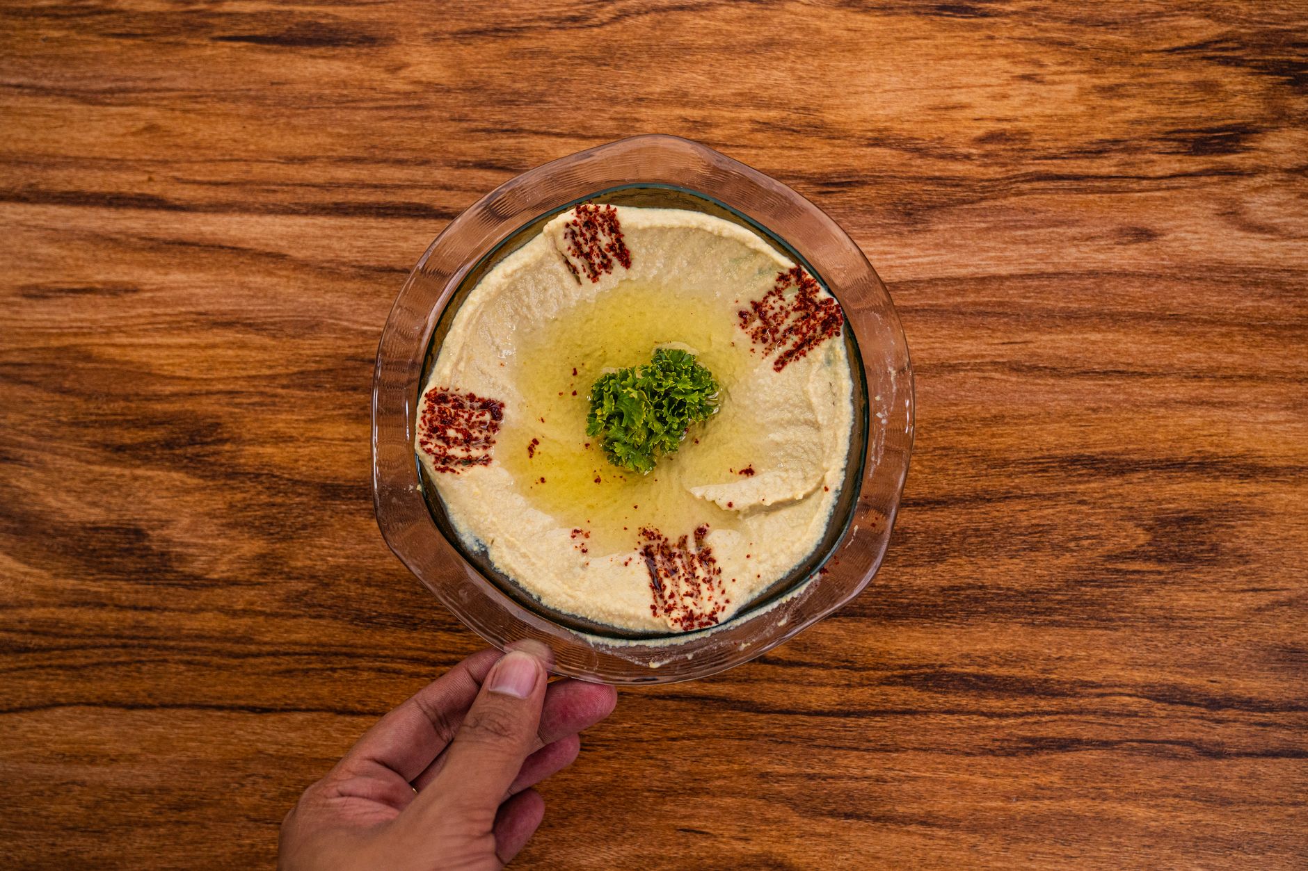 A bowl of roasted red pepper hummus surrounded by pita chips