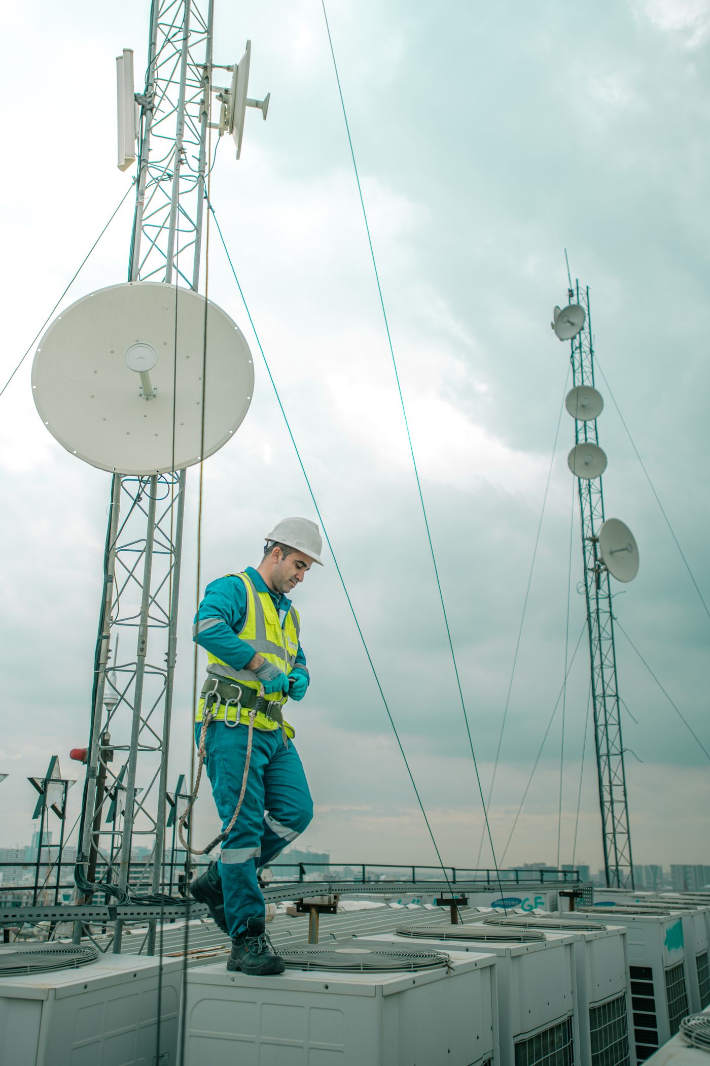 Telecommunications worker working on rooftop equipment