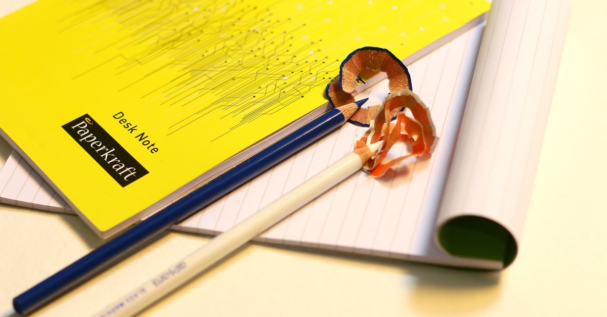 Illustrative workspace photograph: Vibrant stationery set featuring sharpened pencils and labeled notebooks on a desk.