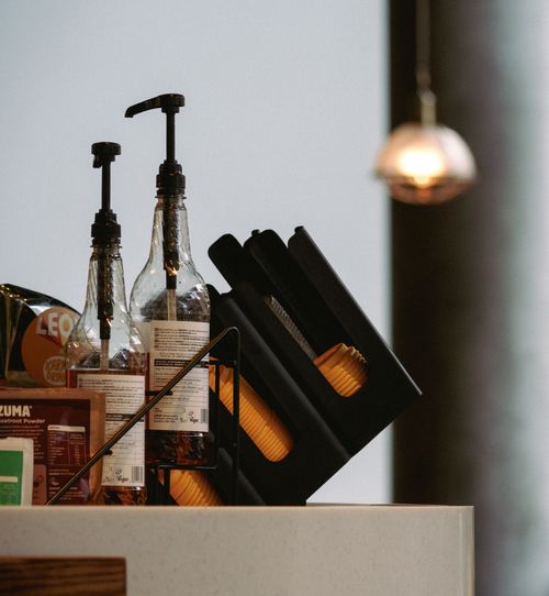 Free Close-up of a café counter with pump bottles, menu and coffee accessories. Stock Photo