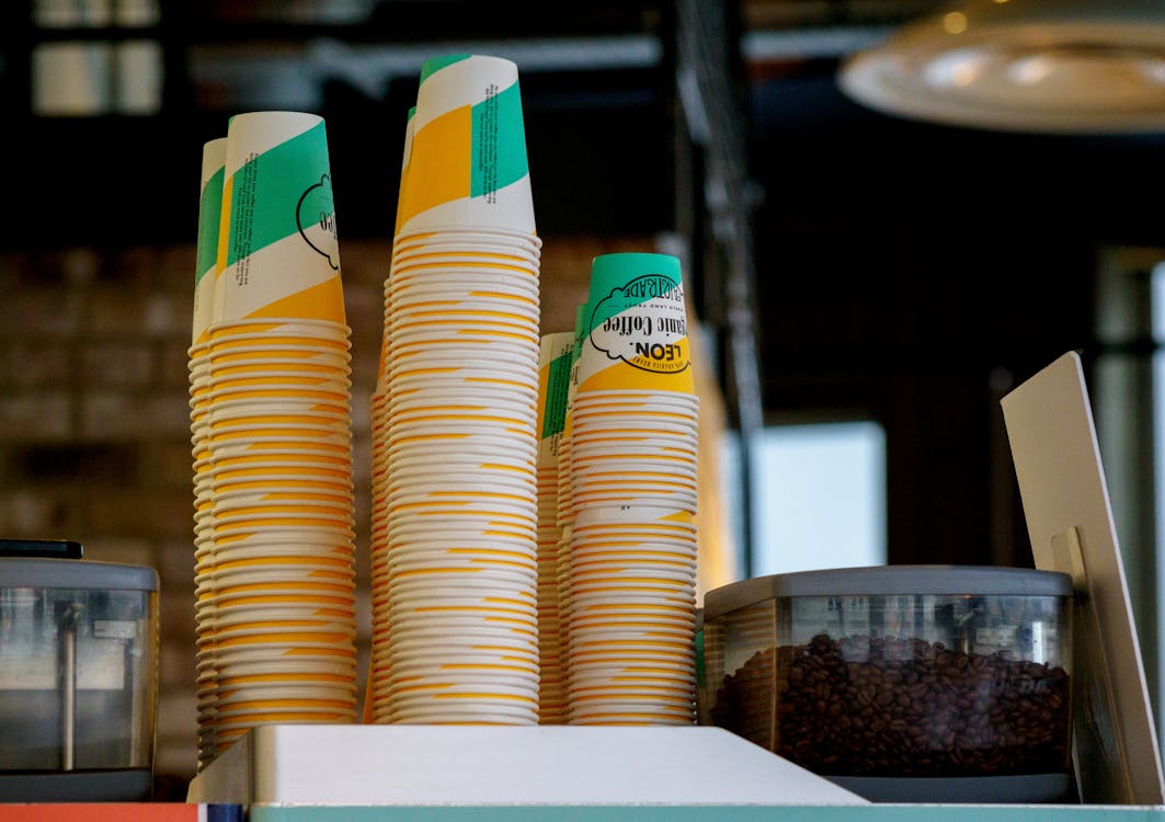 Close-up of Stacks of Disposable Cups Standing next tot a Coffee Machine in a Cafe