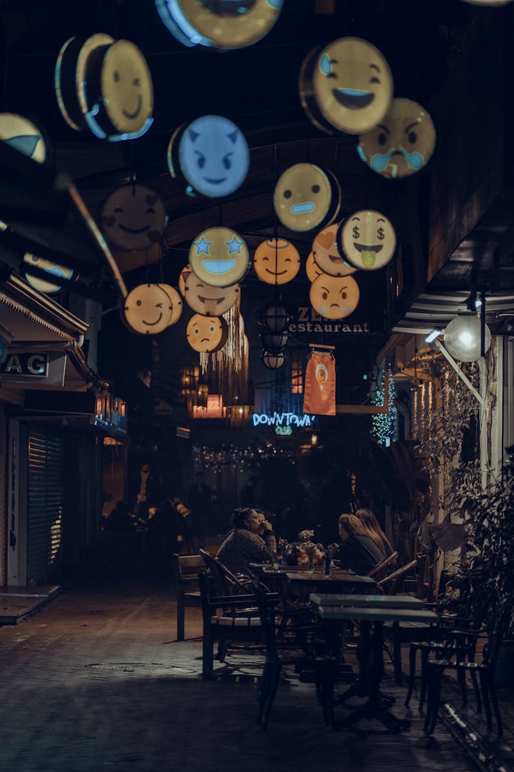 Photo Of People Sitting In A Street Restaurant At Night