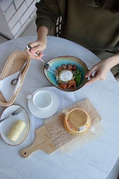 Overhead view of a colorful healthy breakfast with poached egg and salad on a rustic table.