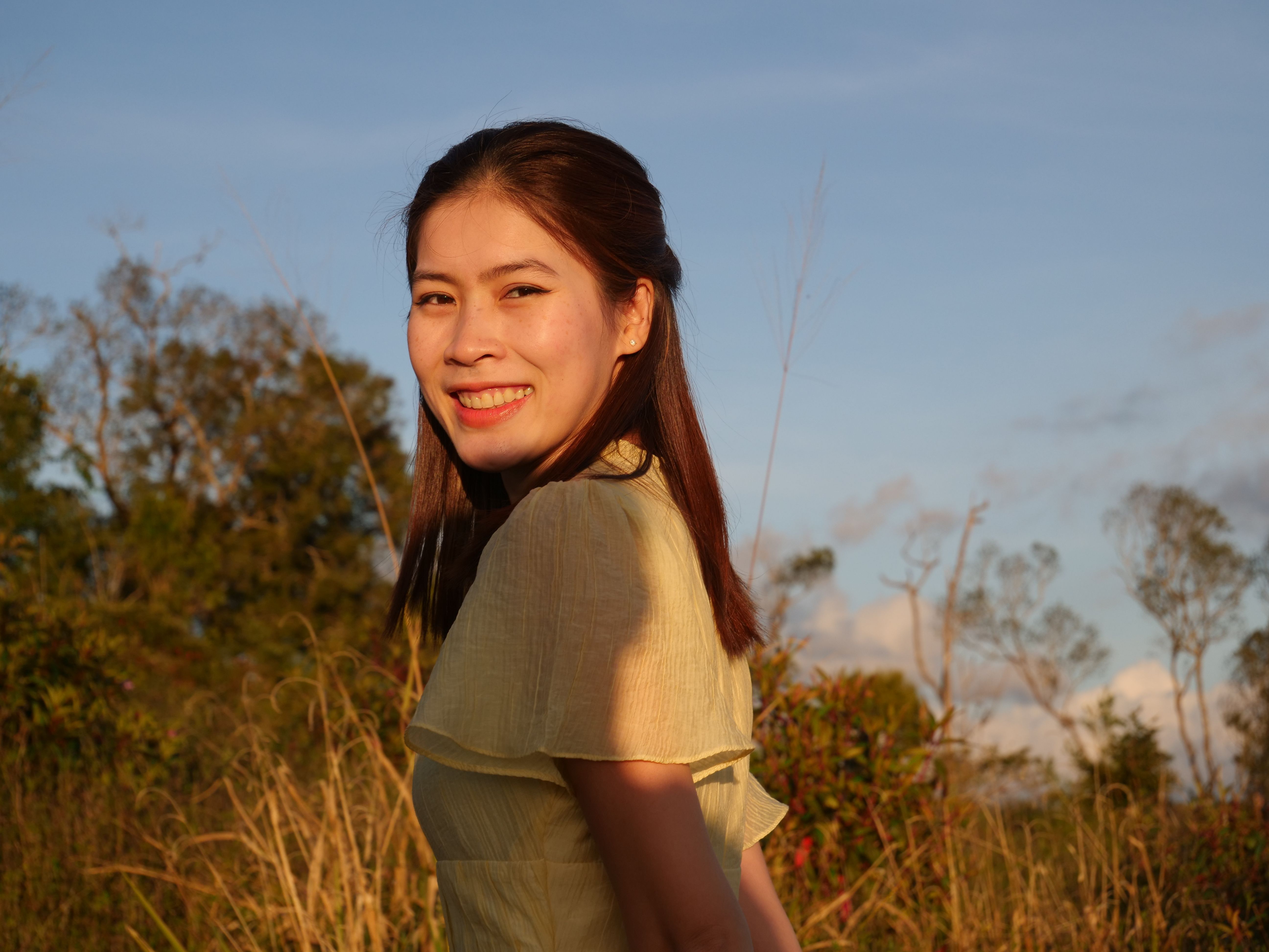 A person smiling while looking out at a unique and unexpected landscape