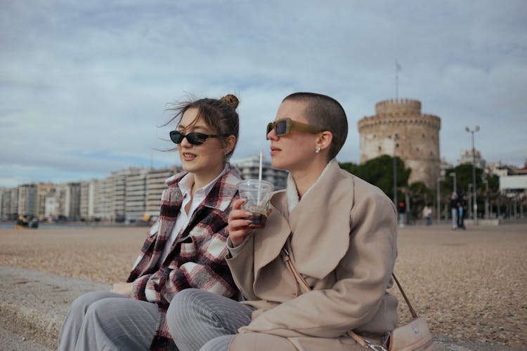 Young Women Sitting On The Beach And Talking 