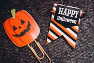 这款万圣节回形针采用南瓜设计，并配有“万圣节快乐”文字的条纹横幅