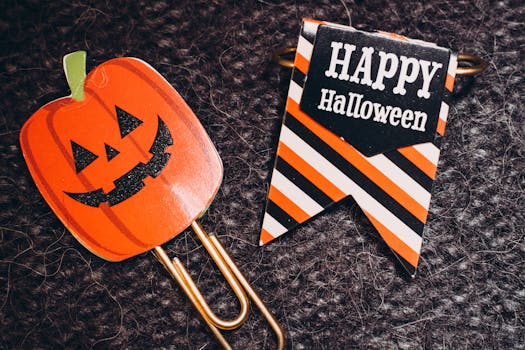 这款万圣节回形针采用南瓜设计，并配有“万圣节快乐”文字的条纹横幅