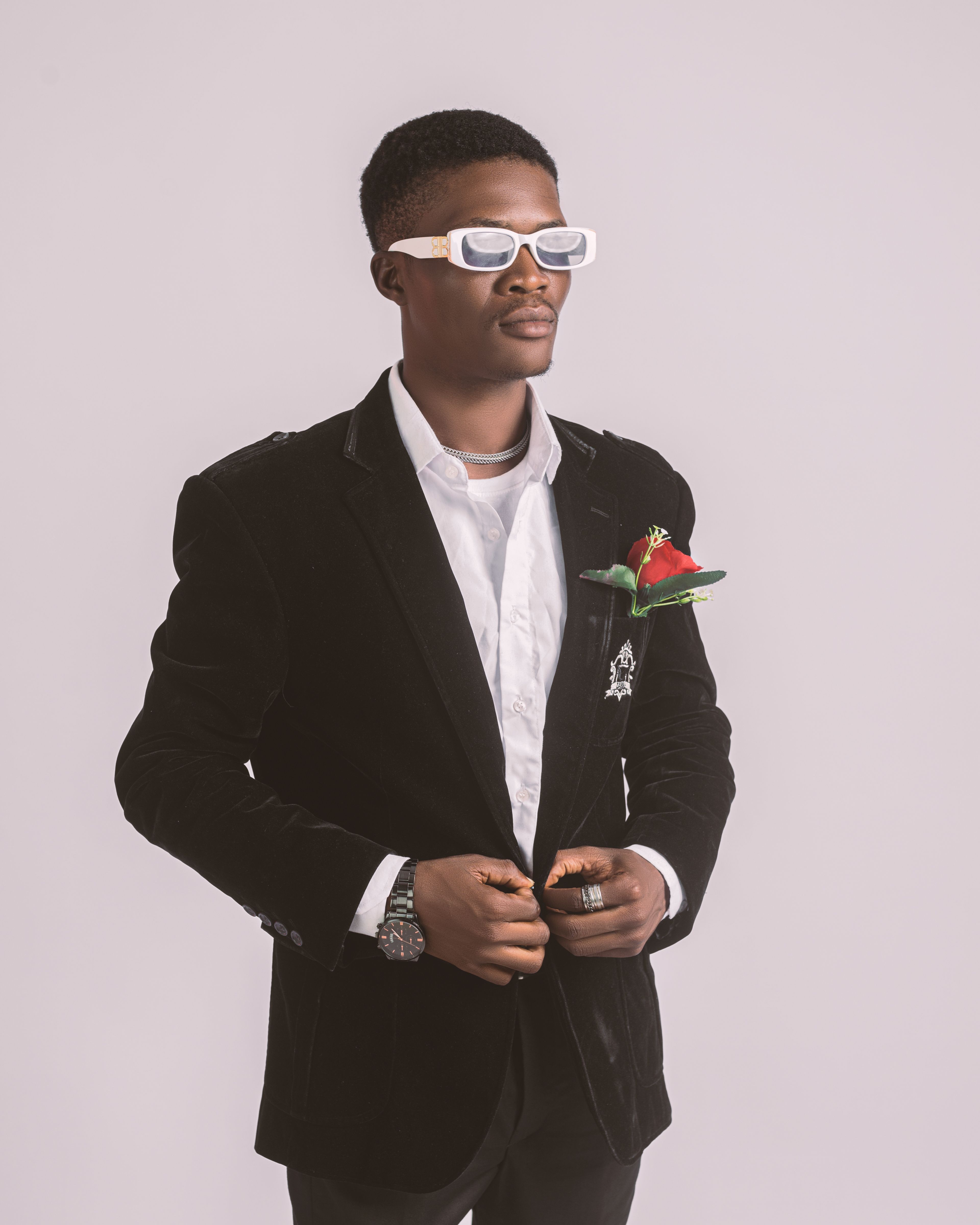 Elegant portrait of a fashionable man in a blazer and sunglasses, exuding modern style.