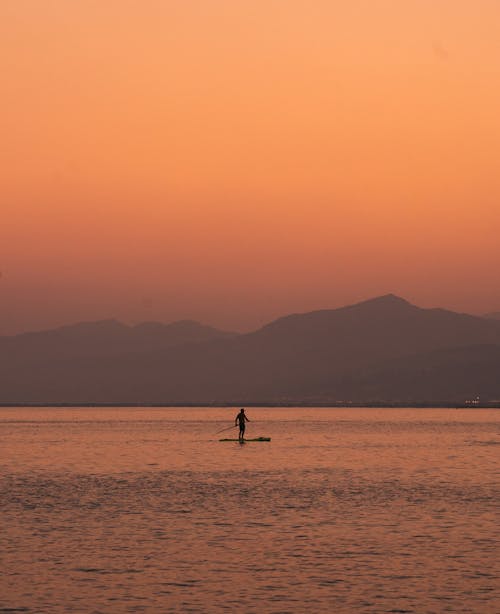 Tourist Paddleboarding at Sunset