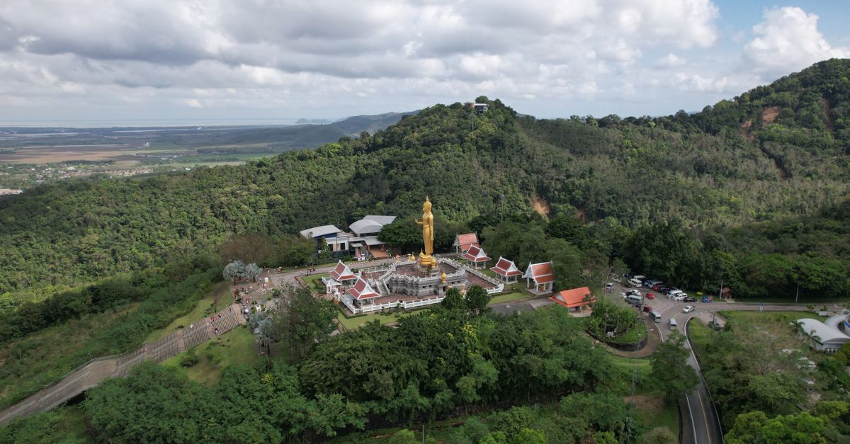 A stunning aerial shot of the Golden Buddha statue surrounded by lush greenery in Kho Hong, Thailand.