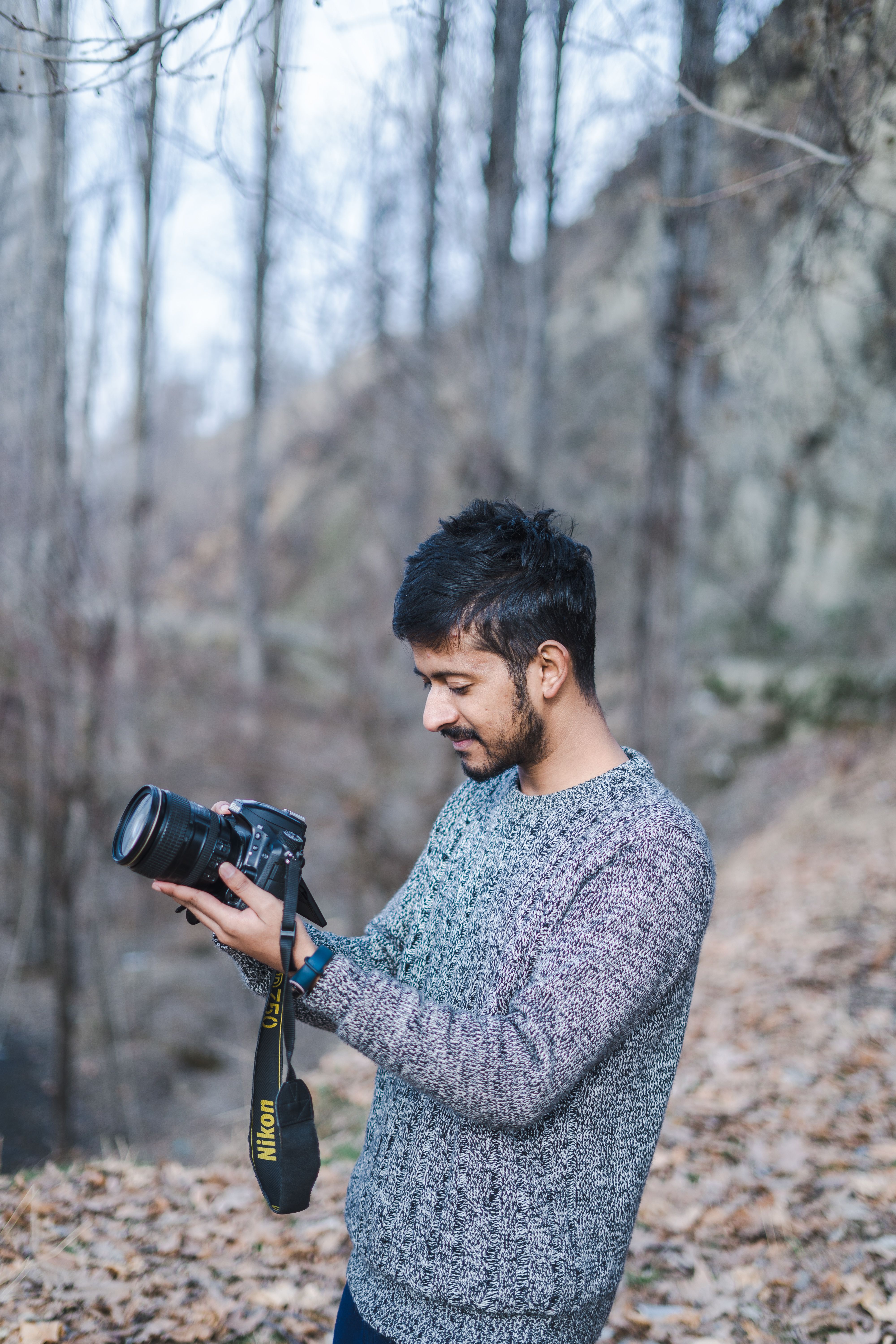 Man photographing nature in an autumn forest, enjoying outdoor photography.