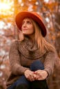 秋天，女人戴着温暖的针织帽，沐浴在阳光中