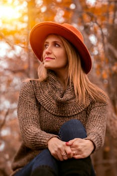 秋天，女人戴着温暖的针织帽，沐浴在阳光中