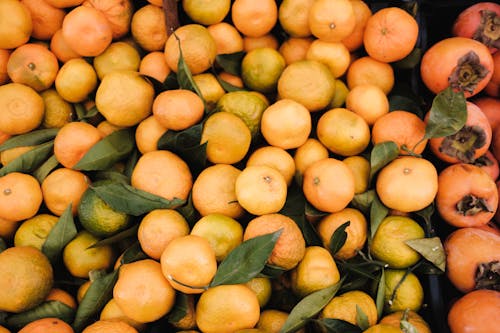 Top View of Mandarins and Persimmons on a Market Stall 