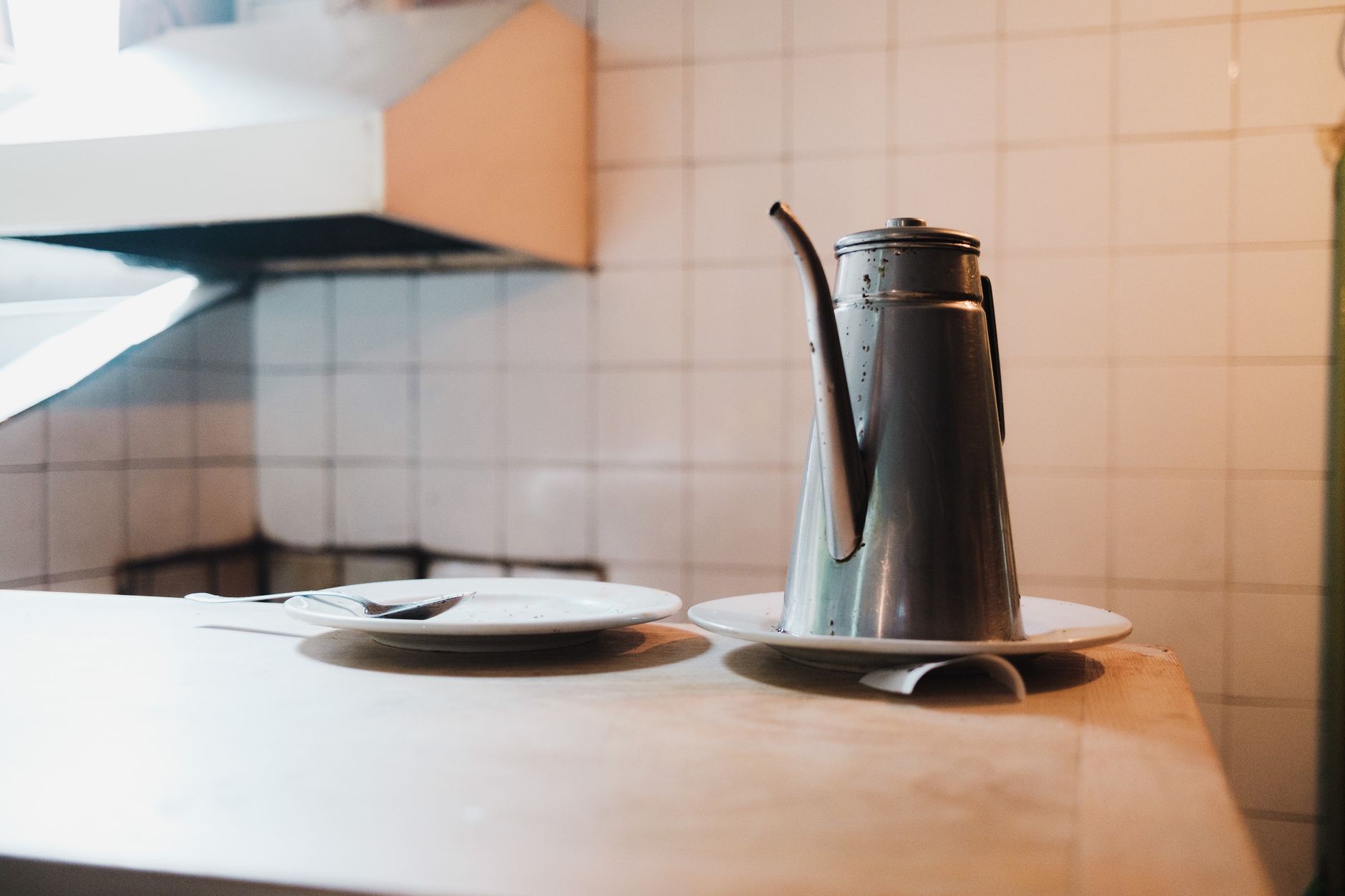 Organized kitchen corner with plate dispenser and utensil holder