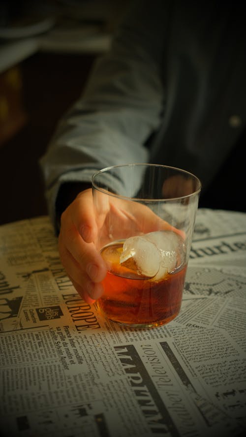 Man Holding Glass with Whiskey on the Rocks