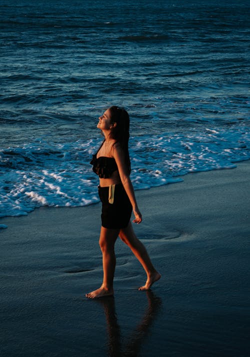 Woman Walking Barefoot on Sand