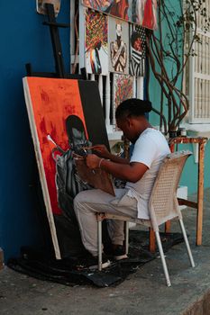 A talented artist creates vibrant street art in Cartagena, Colombia.